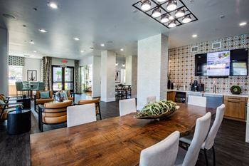 A modern dining room with a wooden table and chairs.